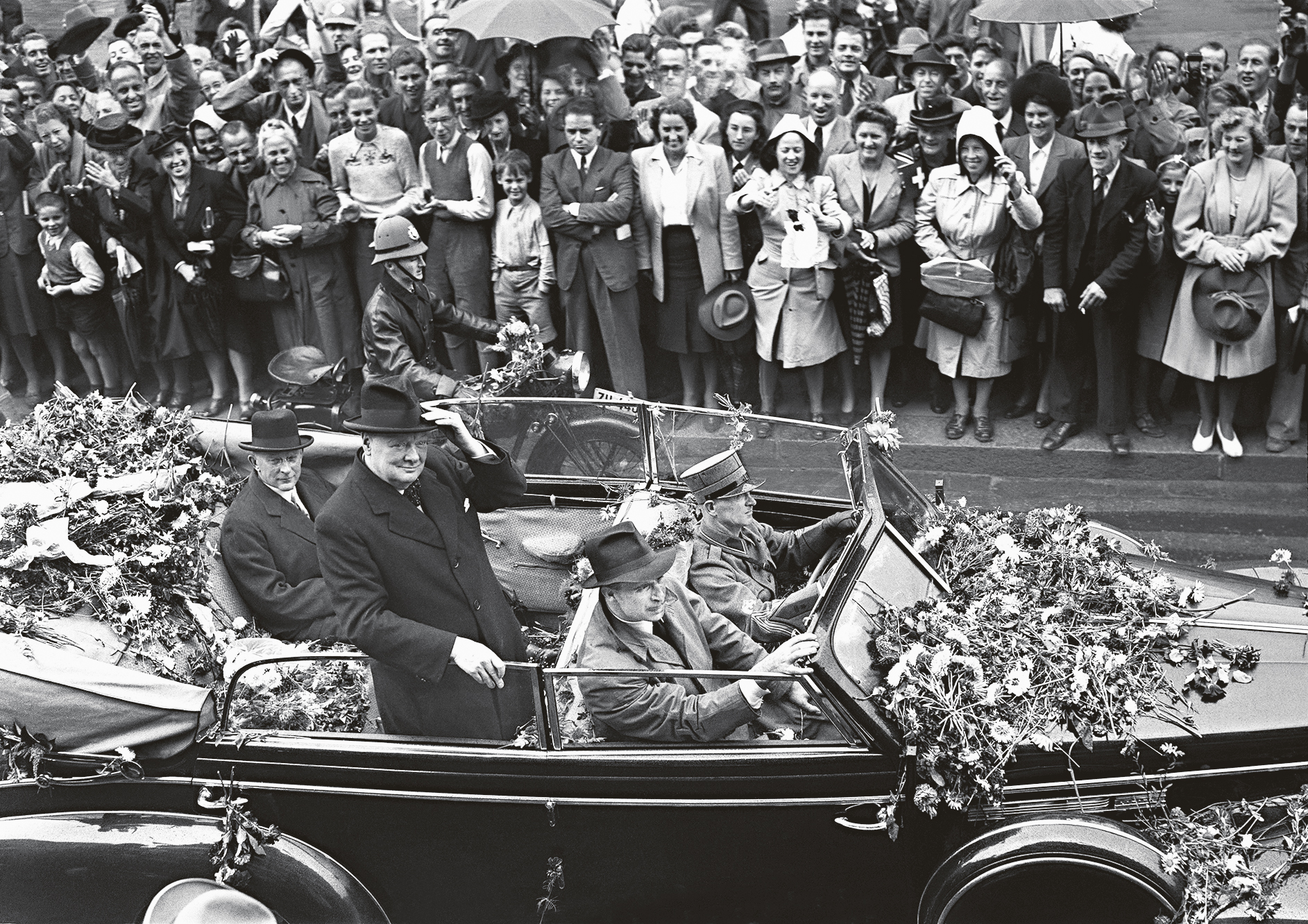 Churchill is driven past cheering crowds through the streets of Zurich