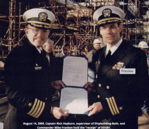 Captain Rick Hepburn, supervisor of Shipbuilding-Bath, and Commander Mike Franken hold the “receipt“ of DDG81.